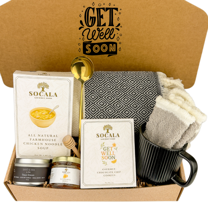 Get well soon care package with SOCALA products and a mug with a blanket and hot chocolate.