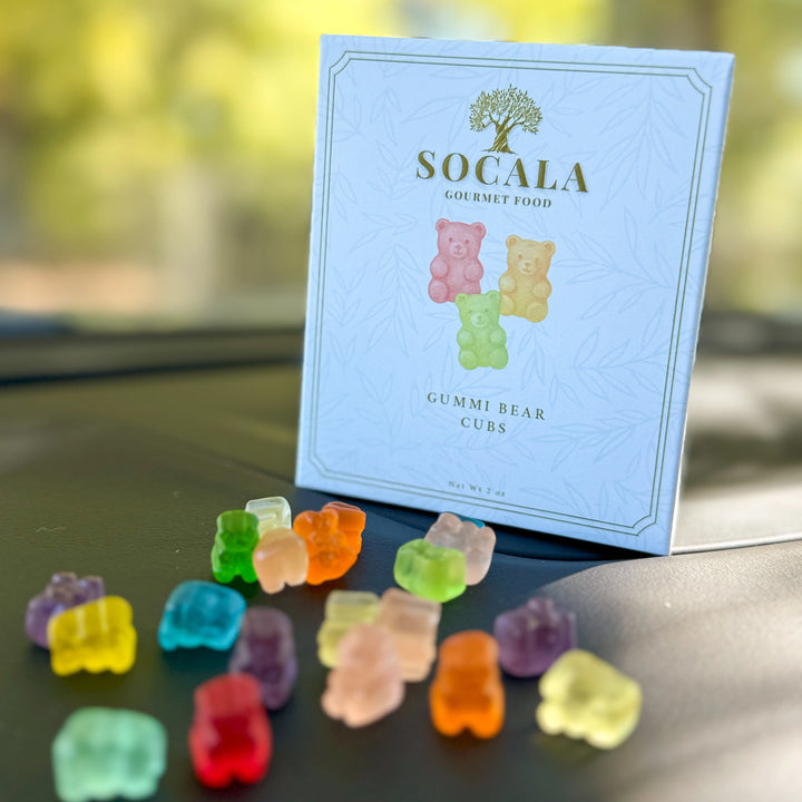Colorful gummy bear candies in front of a SOCALA Gourmet Food package.