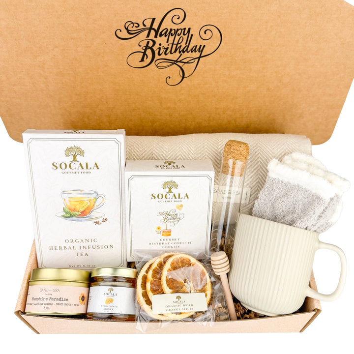 Gift box with blanket, tea, cookies, and other items, featuring 'Happy Birthday' text.