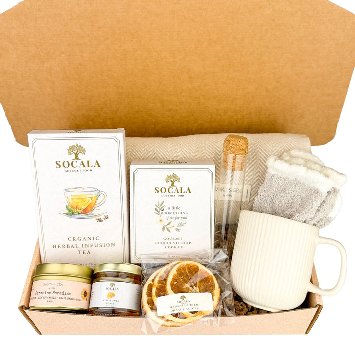 Tea gift set with a luxury blanket, Socala tea, a mug, and other items in a box.