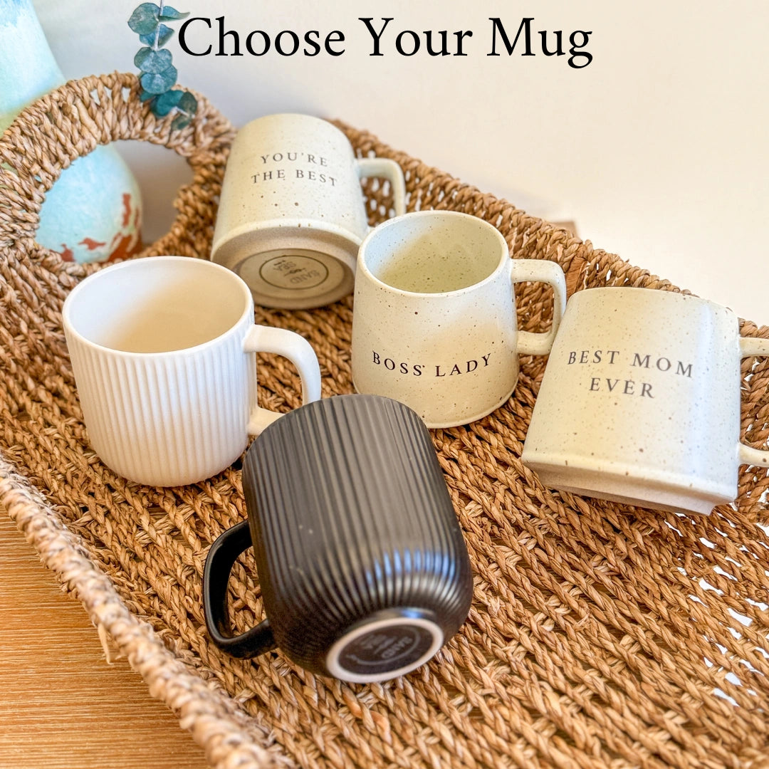 Five ceramic mugs with text on a woven tray