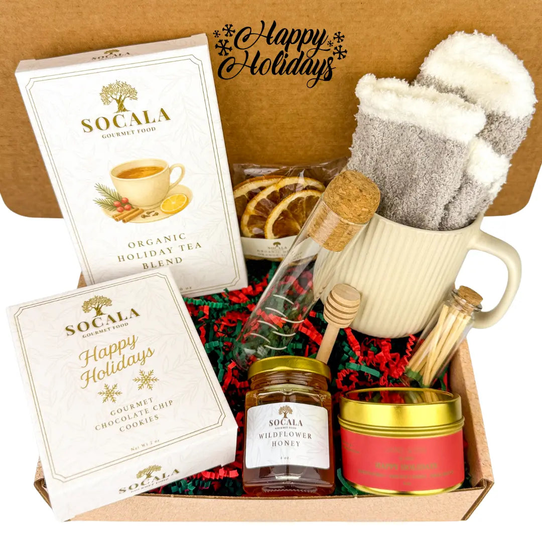 Gift set with Socala tea, cookies, honey, and a candle in a box labeled 'Happy Holidays'.