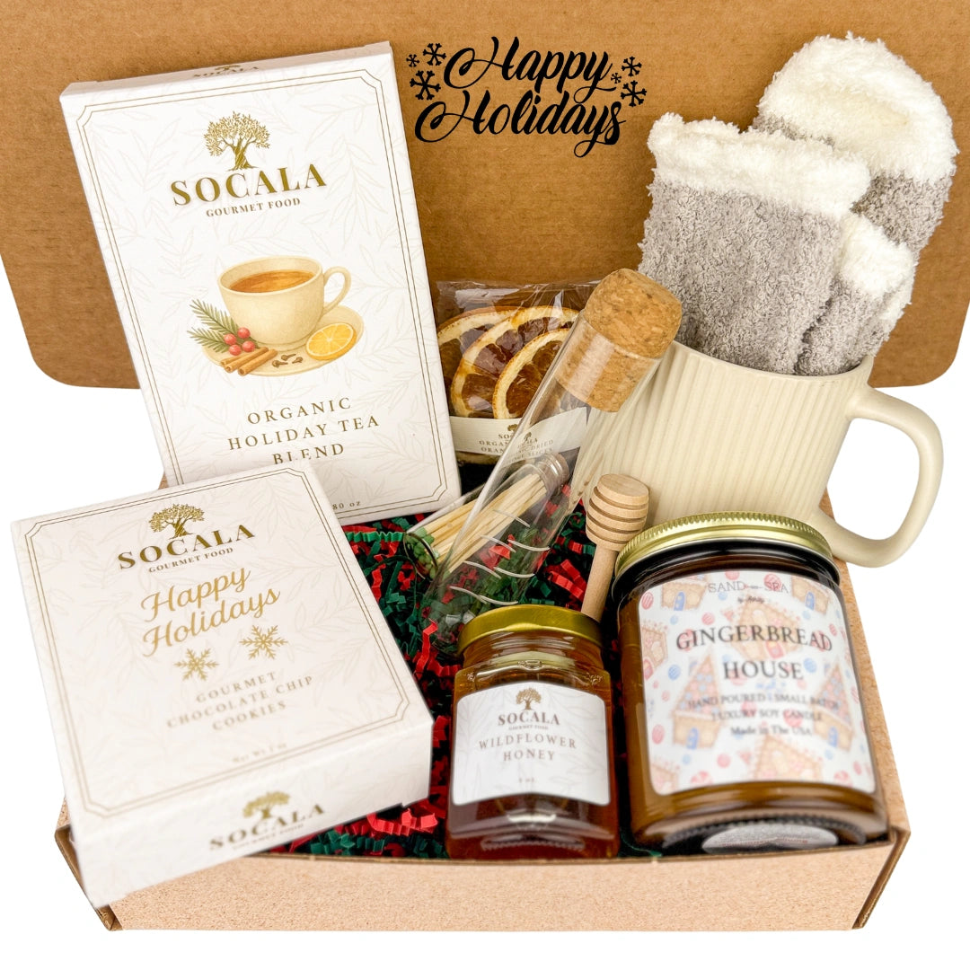 Gift set with Socala tea, honey, and a gingerbread house candle in a box with 'Happy Holidays' text.