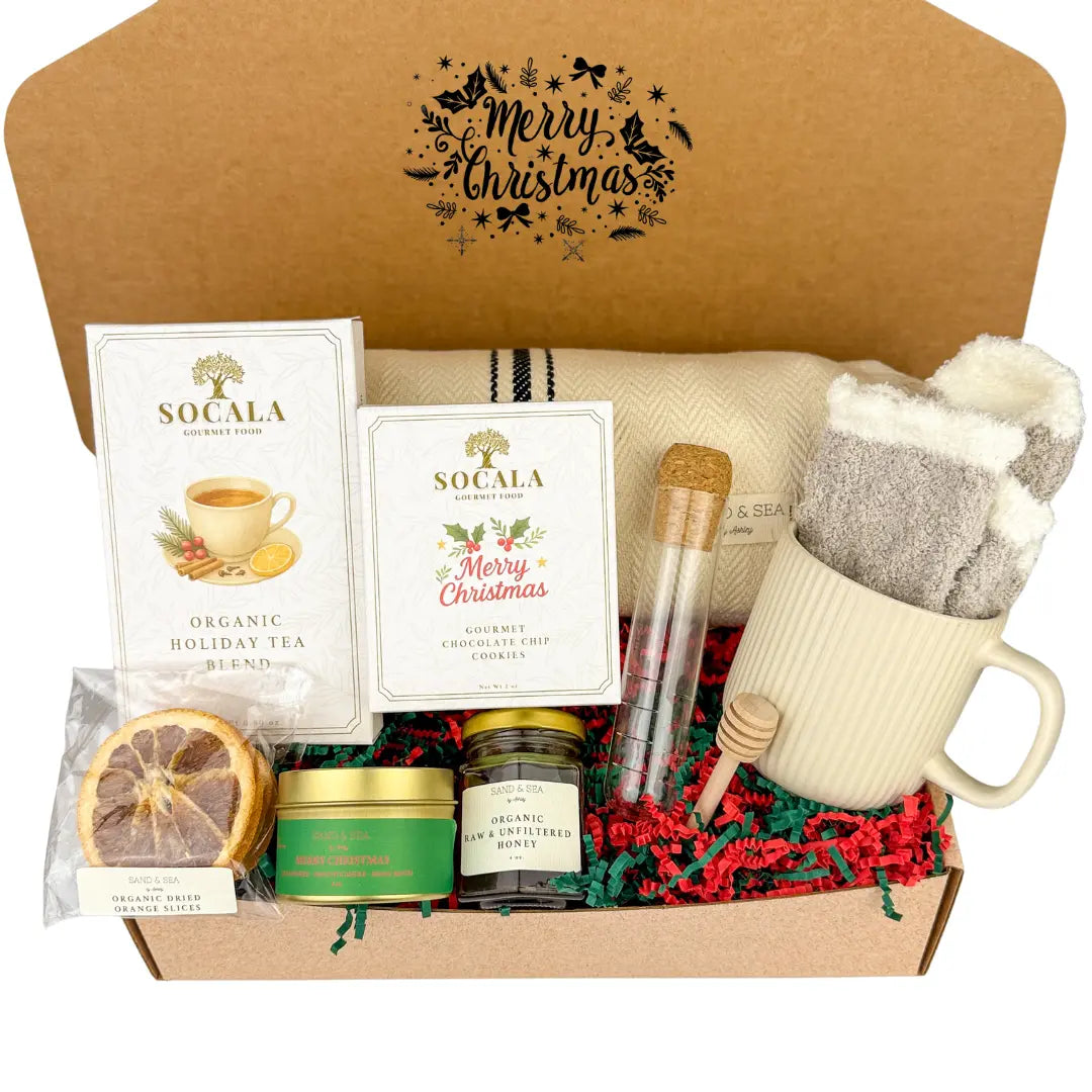 Gift box with holiday-themed items including tea, candles, and a mug.