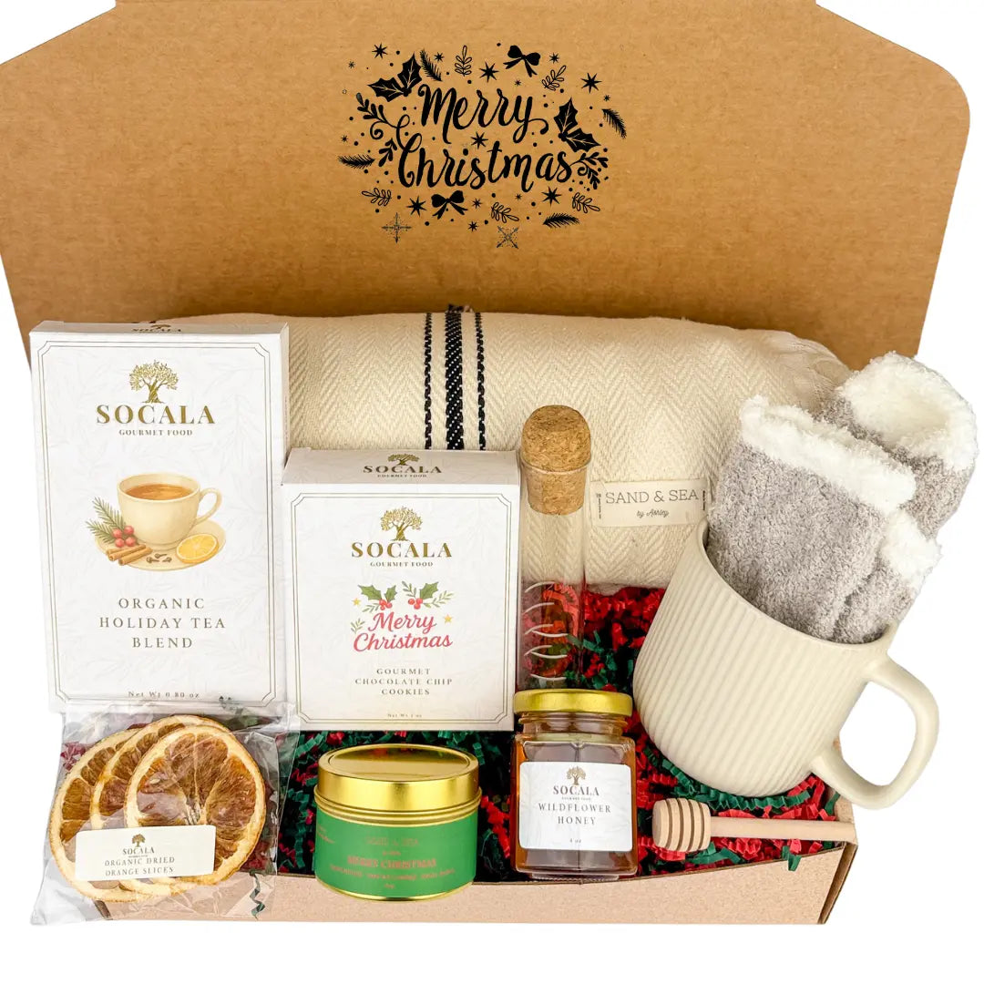 Gift box with holiday-themed items including tea, candles, and a mug.