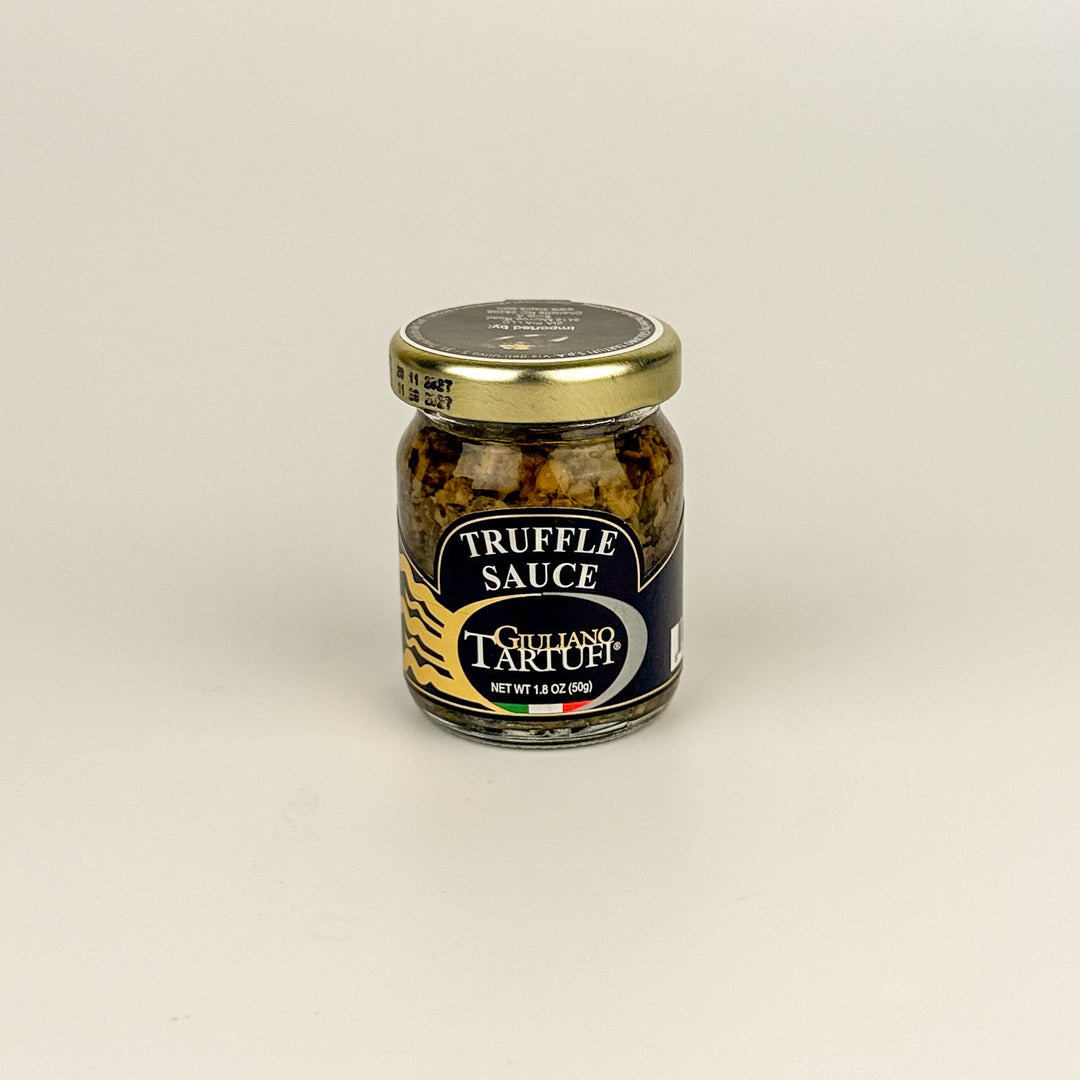 Jar of truffle sauce with a gold lid on a beige background