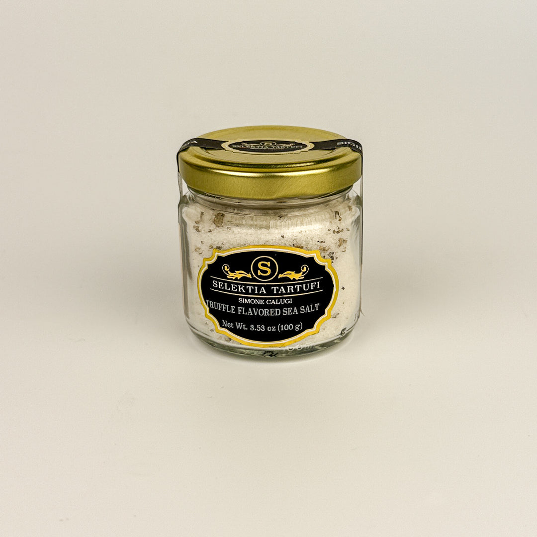 Jar of truffle-flavored sea salt with a gold lid on a beige background