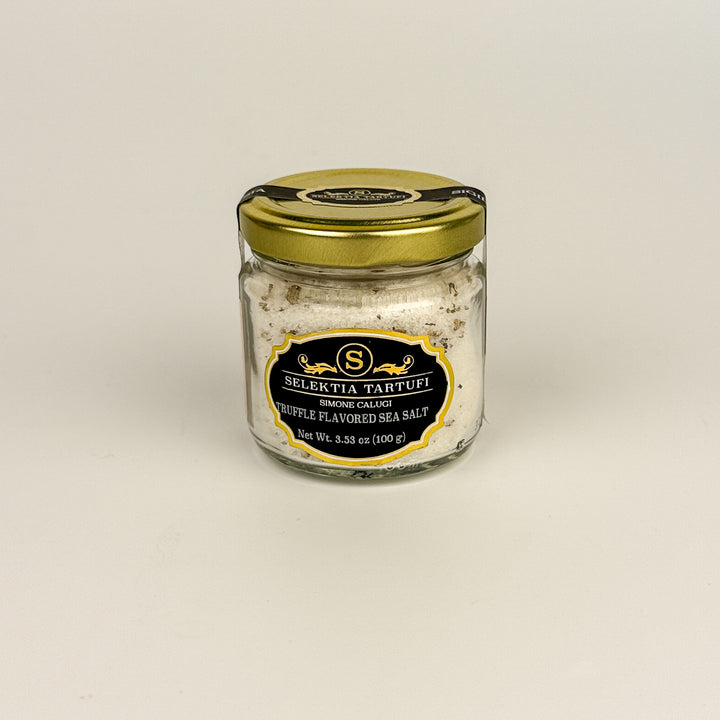 Jar of truffle-flavored sea salt with a gold lid on a beige background