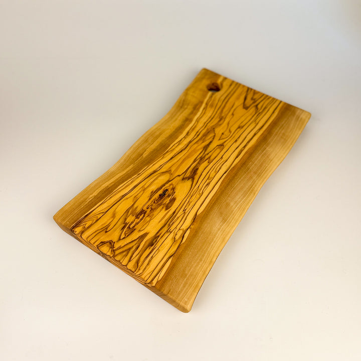 Olive Wood cutting board with a natural grain pattern on a white background