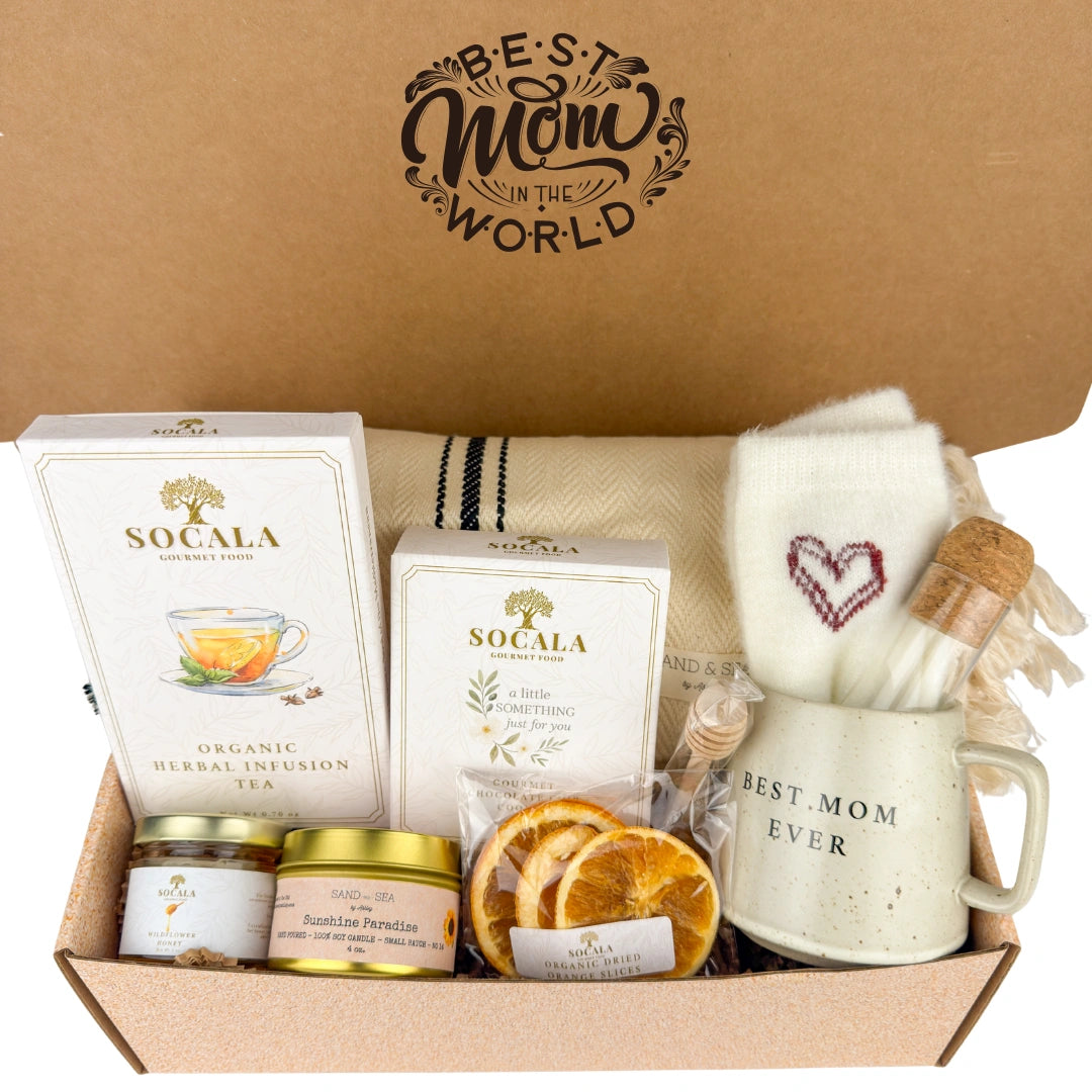 Gift box with tea, candles, and a mug labeled 'Best Mom Ever' on a brown background.