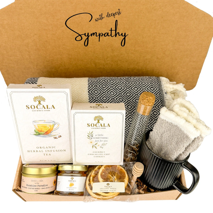 Sympathy gift box with tea, honey, and other items on a white background
