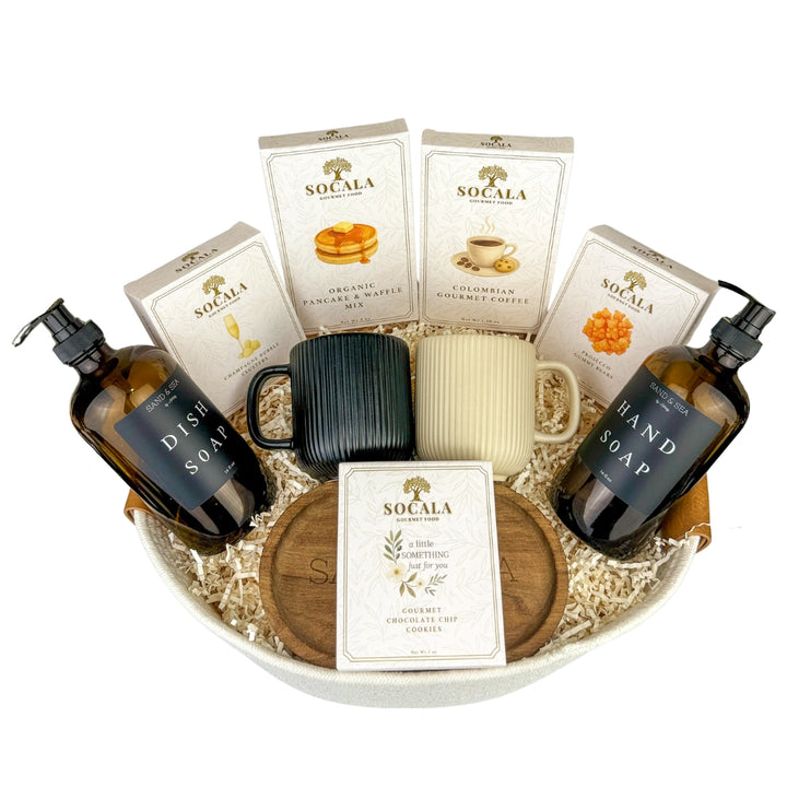 Gourmet gift basket with Socala products including dish soap, hand soap, mugs, and coffee on a white background.