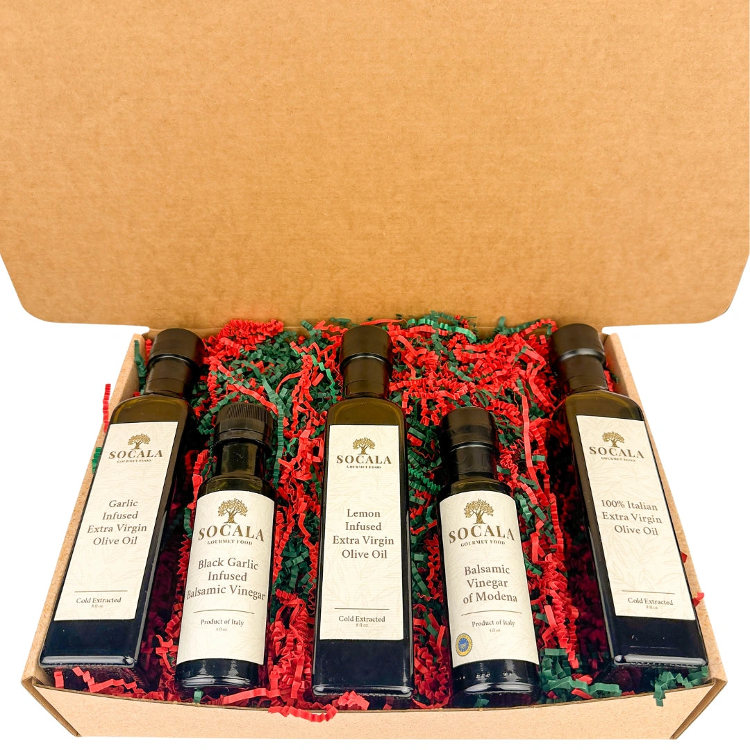 Set of SoCalca olive oil and vinegar bottles in a box with red and green crinkle paper.