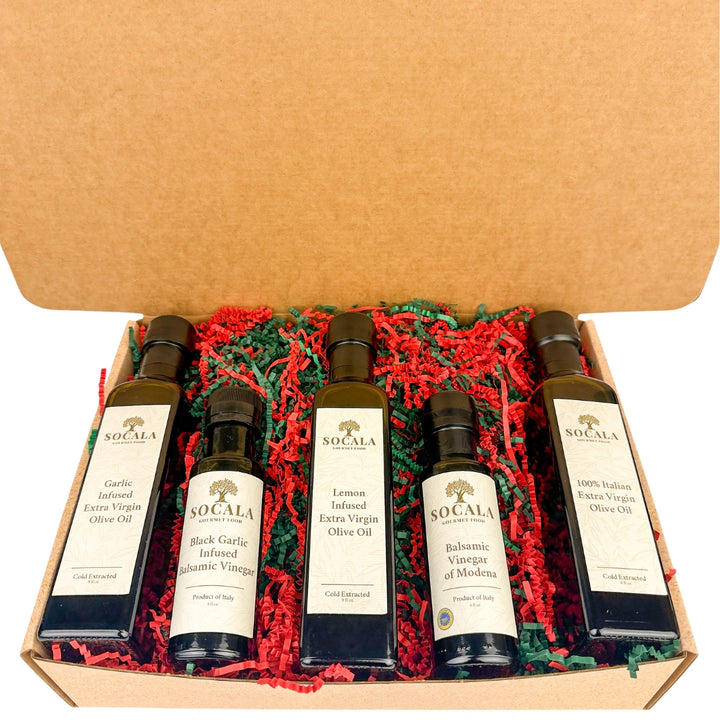 Set of SoCalca olive oil and vinegar bottles in a box with red and green crinkle paper.