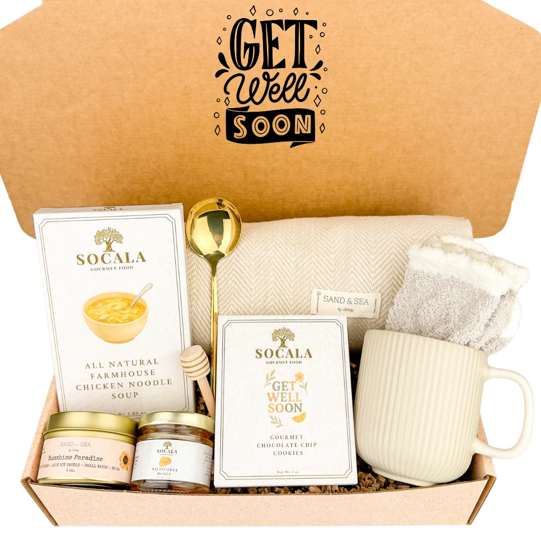Get well soon care package with a mug, chicken noodle soup, cookies, blanket, and other items in a box.