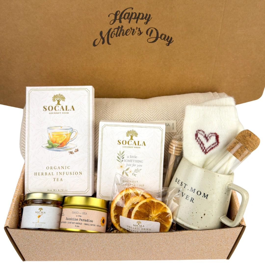 Gift box with tea, snacks, and a mug on a brown background