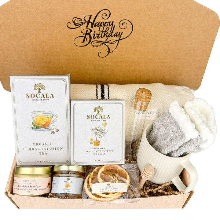 Gift box with farmhouse blanket, tea, cookies, and other items, featuring 'Happy Birthday' text.