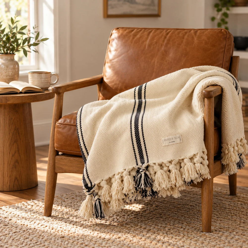 Harvest Coast striped throw blanket draped over a leather armchair
