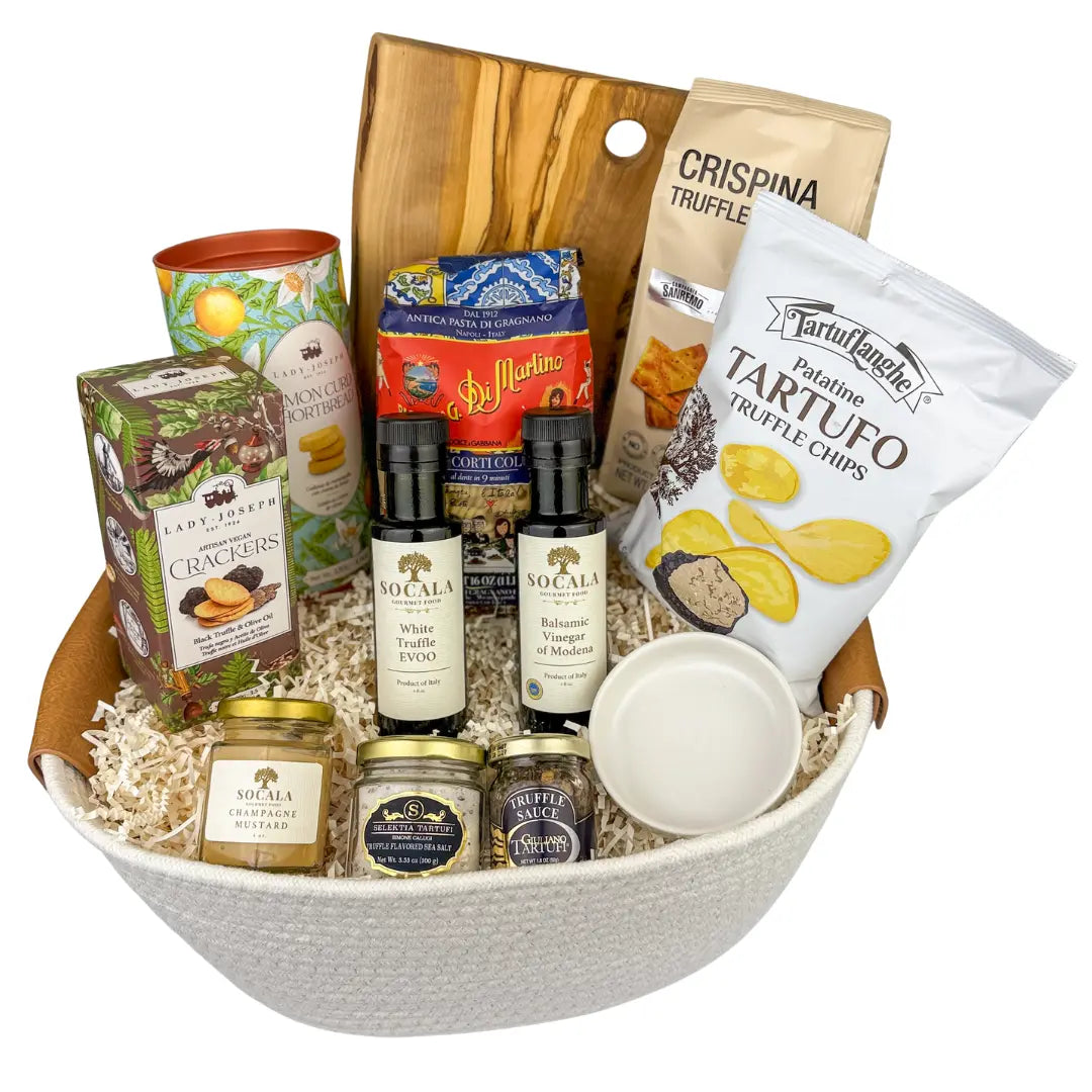 Gourmet gift basket with truffle products and snacks on a white background