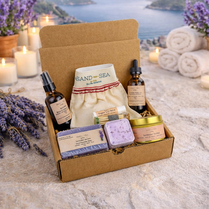 Box of lavender-themed products with candles and lavender flowers on a scenic background