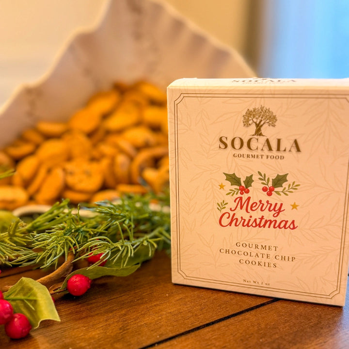 Box of Socala Gourmet Food cookies with Christmas design on a wooden surface.