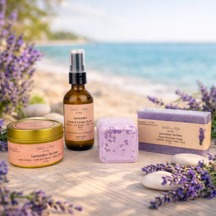 Lavender-themed products including a bottle, jar, soap, and shower steamer on a wooden surface with a blurred beach background.
