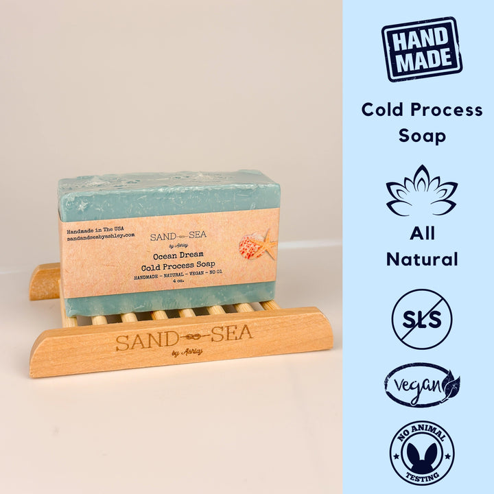 Bar of Sand Sea soap on a wooden stand with product details on a light blue background