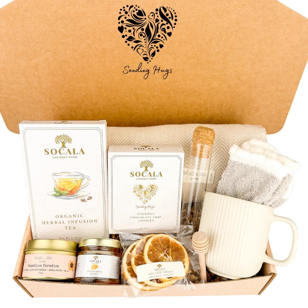 Blanket and tea gift set with 'Socala' tea boxes, a mug, and other items in a decorative box.