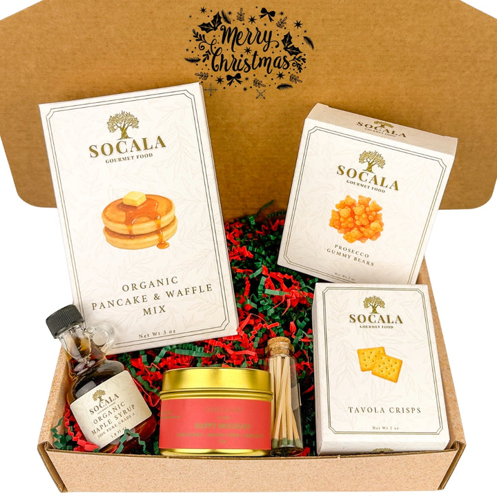 Socala gourmet food items including pancake mix, gummy bears, and crackers in a Christmas-themed box.