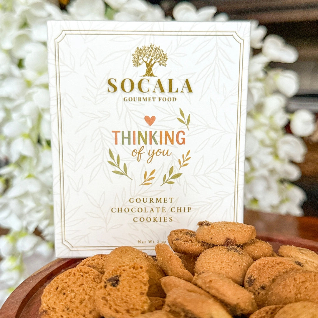 Cookies on a wooden plate with a 'Socala Gourmet Food' box in the background.