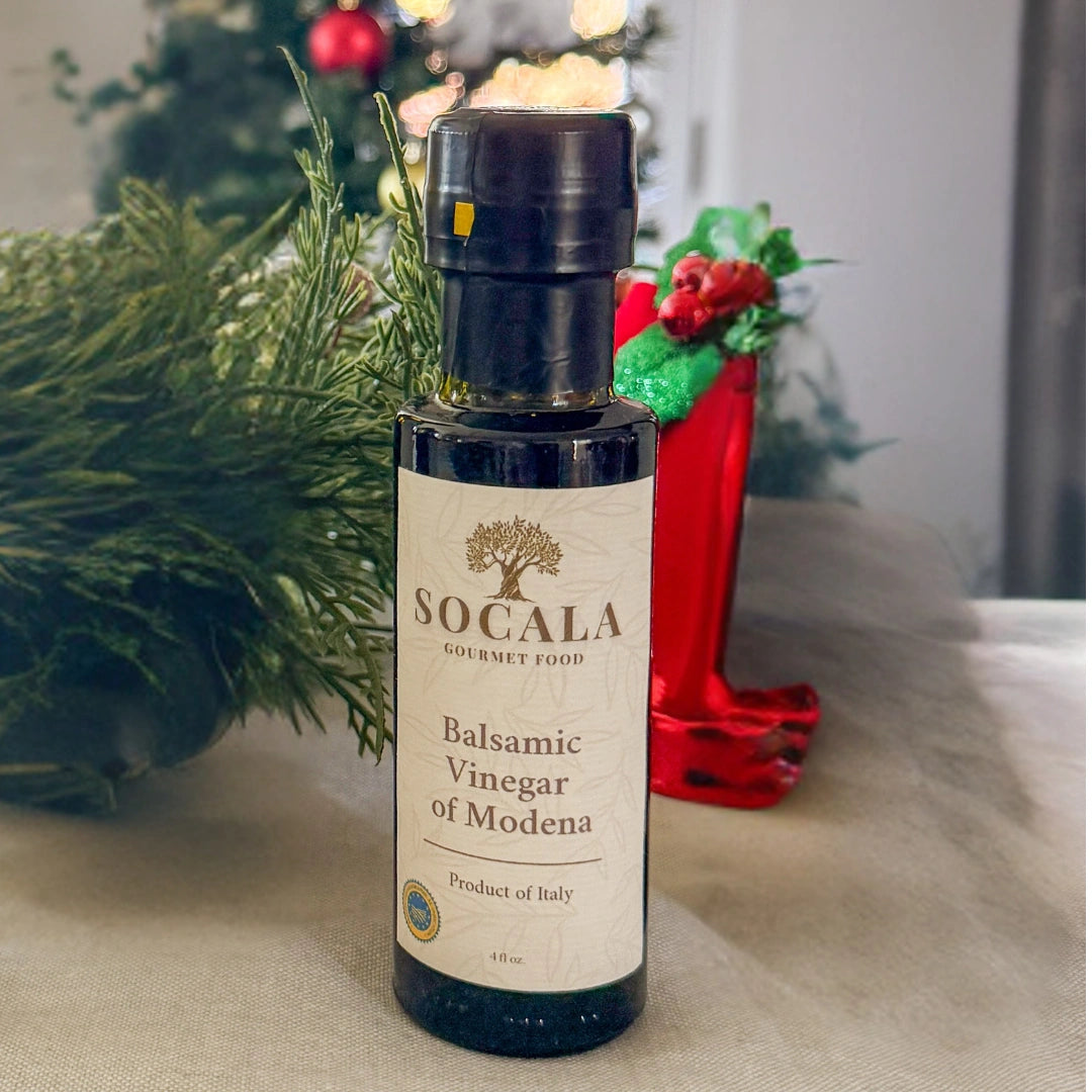 Socala Balsamic Vinegar of Modena bottle on a table with decorative items in the background