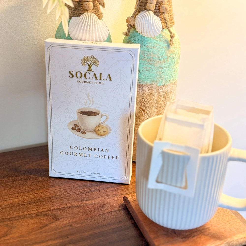 Socala Colombian Gourmet Coffee package with a white mug on a wooden surface.