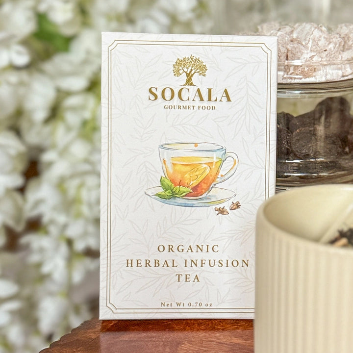 Socala Gourmet Food organic herbal infusion tea package with a cup of tea illustration on a wooden surface.