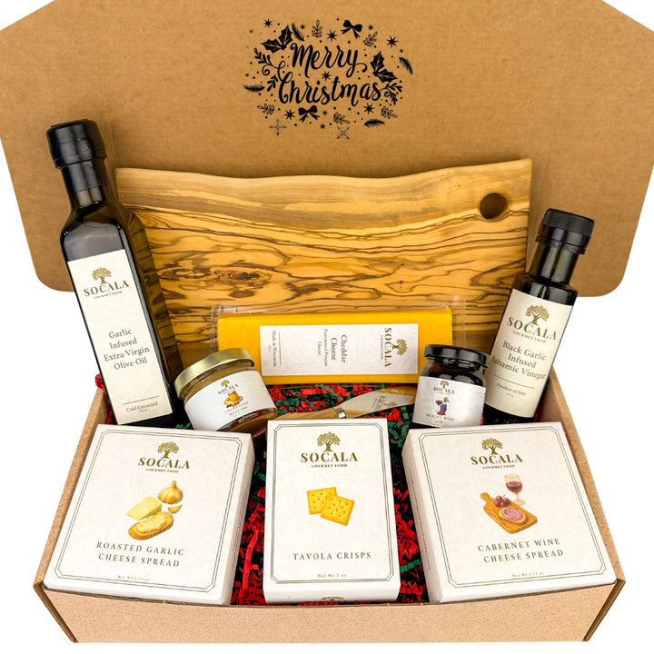 Gourmet gift set with Socala products including olive oil, cheese, and crackers in a Christmas-themed box.
