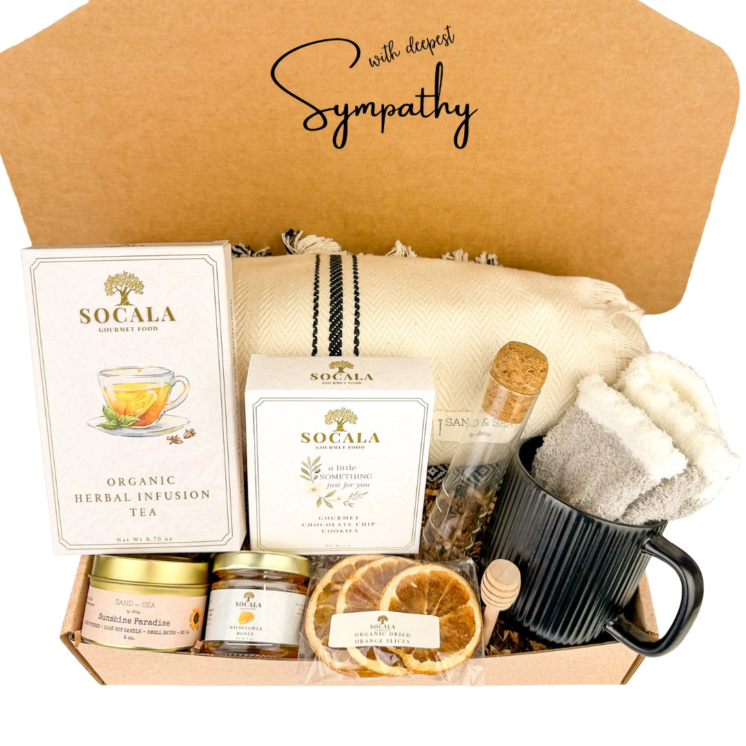 Sympathy gift box with blanket, tea, snacks, and a mug.