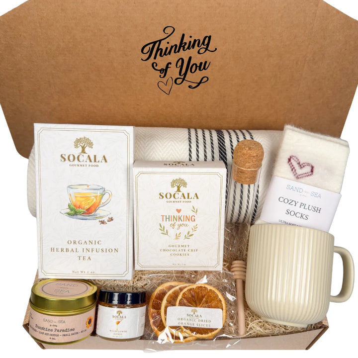 Gift box with blanket, tea, cookies, and other items labeled &